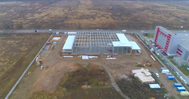 Baustelle eines modernen Industriegebäudes Luftaufnahme. Bau eines großen Logistikzentrums. Eine moderne Großbaustelle überfliegen — Stockvideo