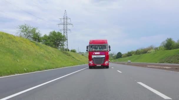 El camión rojo está conduciendo por la carretera. Un grupo de camiones está conduciendo a lo largo de la carretera. Camiones modernos transportan carga líquida en tanques — Vídeos de Stock