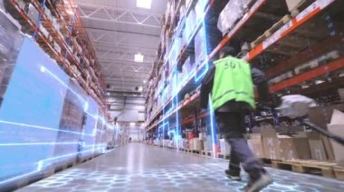 İşçi depoya doğru yürür. Bir işçi büyük bir depoda bir rokla taşıyor. Üretimin dijitalleştirilmesi. Gelecekçi üretim konsepti.