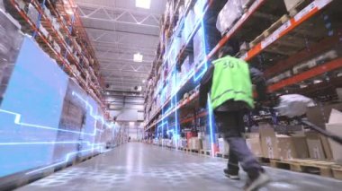 Bir işçi büyük bir depoda bir rokla taşıyor. İşçi depoya doğru yürür. Üretimin dijitalleştirilmesi. Gelecekçi üretim konsepti.