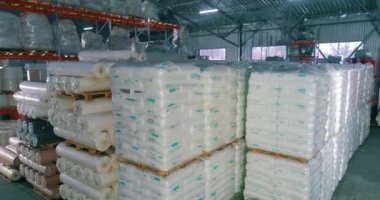 Fabrikadaki hammadde deposu. Üretim için bir sürü hammadde torbası. Spunbond fabrikanın deposunda rulo yapıyor.