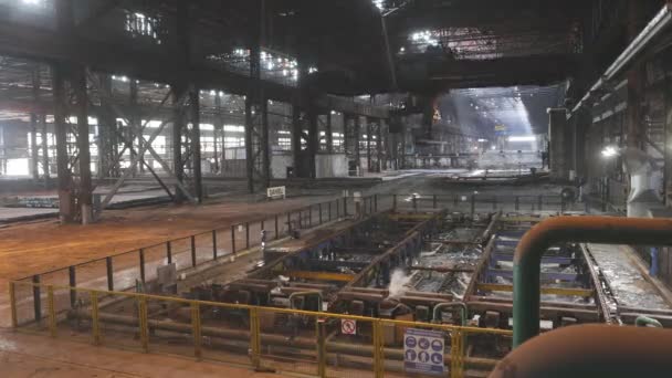 El trabajo de una grúa aérea en el momento regazos planta. Proceso de trabajo en una fábrica de producción de metal. El trabajo de la grúa en el momento regazos planta. Una grúa aérea en una fábrica moderna. — Vídeos de Stock