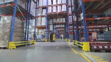 Forklift depodan geçiyor. Hidrolik asansör modern bir depoda hareket ediyor.