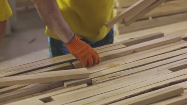 Рабочие на конвейерной линии мебельной фабрики. Рабочие разбирают деревянные блоки на мебельной фабрике. Сортировка заготовок на мебельной фабрике — стоковое видео