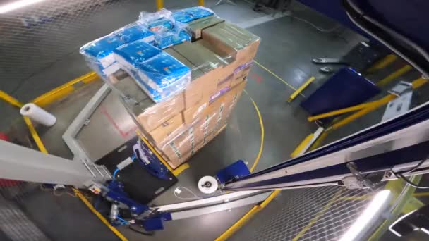 Cajas de embalaje en película de plástico. Caja de envoltura elástica. máquina de embalaje de paletas. Máquina para envolver cajas en una película de plástico en círculo. — Vídeo de stock