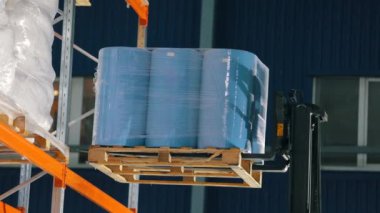 Forklift malları depodaki raflara koyuyor. Depo işi. Agrofiber ambarın rafına konmuş.