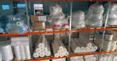 Dokumasız fabrikasındaki depo. Kumaşsız kumaş deposuna uçuş. Sentetik kış sarmalı büyük modern bir depo.