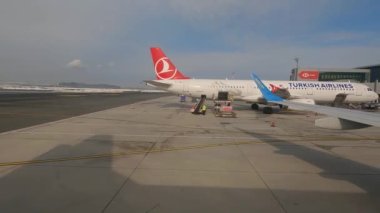 Havalimanı lombozdan geçiyor. Uçak havaalanının etrafında hareket ediyor. Uçak terminale gidiyor.