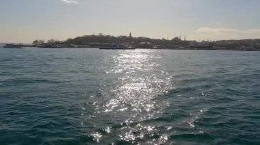Güneş, suya yansıyor. Dalgalar güneşi yansıtıyor.