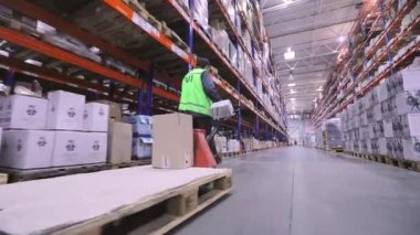 Depoda bir adam bir rokla taşıyor. Büyük bir depoda bir adam bir rokla taşıyor. Depo işçisi. Büyük modern depo