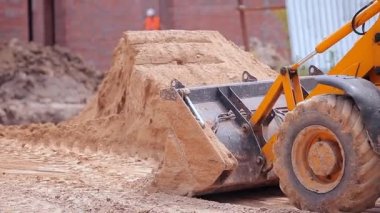 Traktör inşaat alanında çalışıyor. İnşaat alanında çalışma süreci. Traktör kovası yaklaş.