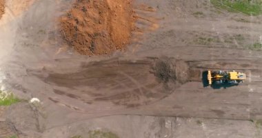 Havadan inşaat alanındaki modern traktör. Büyük sarı traktör. Profesyonel inşaat malzemeleri. İnşaat alanında çalışma süreci