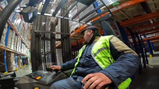 Il lavoro di un carrello elevatore in un punto di vista di magazzino. Moderno carrello elevatore funziona in un magazzino. Lavori di attrezzature speciali nel magazzino, punto di vista — Video Stock