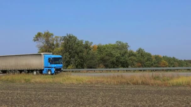 The truck drives along the highway in sunny weather. The truck rides on a modern road. Truck on the track — Stock Video