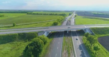 Çok şeritli otoban manzaralı. Büyük bir otoyolun üzerinde uçuyor. Modern bir yol manzarası üzerinde giden arabalar