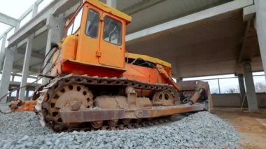Buldozer yere moloz döküyor. Buldozer toprağı düzleştiriyor. İnşaat alanında büyük sarı bir buldozer. Sarı buldozer inşaat alanında çalışıyor..