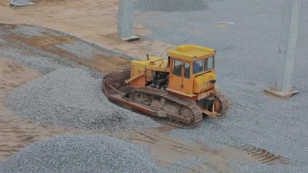 บูลโดเซอร์ที่สถานที่ก่อสร้าง รถปราบดินสีเหลืองที่สถานที่ก่อสร้าง อุปกรณ์ก่อสร้างหนัก — วีดีโอสต็อก