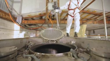 Kimyasal koruma işçisi. Temizlik istasyonunda koruyucu takım elbiseli bir işçi. İşçi zararlı kimyasallarla çalışır.