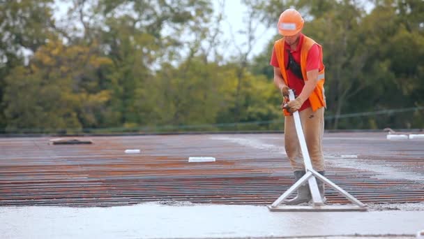 Um trabalhador nivela uma camada de concreto em uma estrutura de concreto armado. Trabalhando com concreto em um canteiro de construção.Criação de cofragem — Vídeo de Stock