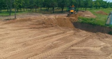 İnşaat alanında büyük sarı bir traktör. İnşaat alanında çalışma süreci. İnşaat alanında profesyonel ekipman.