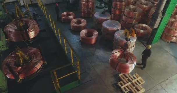 Flujo de trabajo en una fábrica de cables. Hombres moviendo una bobina con un cable de cobre — Vídeos de Stock