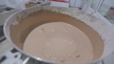 Waffle için hamur topluyorum. Waffle kabı pişirmek için hamur hazırlığı. Yiyecek üretimi. Fabrikada para kazanma süreci.