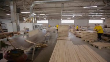 Marangozhanenin içinde. İşlenmiş ahşap parçaları düzgünce katlanmış. Bir marangoz fabrikasında çalışma süreci