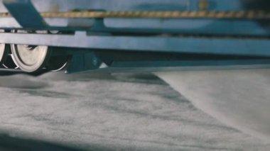 Sentetik kış sökücü üretimi. Sentetik kışlık konveyör hattında, yakın plan. Dokumasız malzeme üretimi için bir fabrika. Syntepon üretim süreci