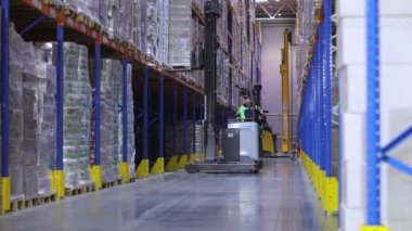 Depo işi. Büyük bir depoda iş akışı. Fabrikanın deposunda özel ekipman var. Modern yükleyiciler büyük bir depoda..