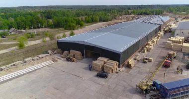 Büyük, modern bir kereste fabrikasının üzerinde uçan tren, tepeden kereste fabrikası manzarasının yanında duruyor. Modern marangoz fabrikası hava manzarası