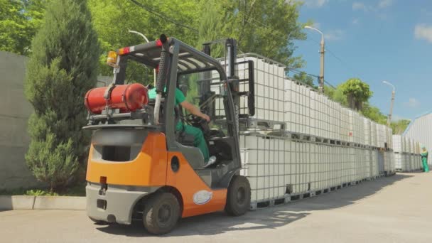 Forklift mengangkat wadah dengan cairan. Forklift membawa wadah di sekitar pabrik. Operasi forklift udara terbuka — Stok Video