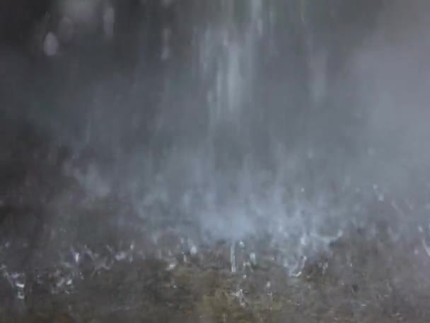 A stream of hot water falls to the floor and evaporates. Close-up of water drops. Waste water droplets fall to the floor, steam from hot falling water — Stock Video