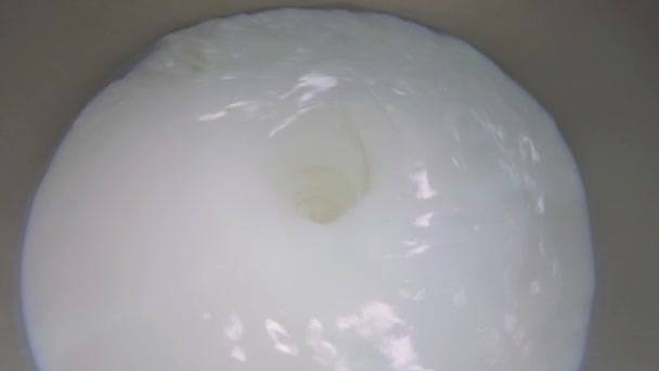 Подготовка мороженого. Размешивание молока на заводе. Молоко вращается в большой бочке — стоковое видео