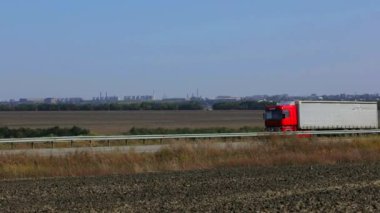 Kamyon güneşli havada otoyol boyunca sürer. Kamyon modern bir yolda gidiyor. Pistte kamyon var