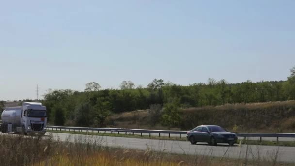 Le camion-citerne roule sur la route. Camion de carburant conduisant sur l'autoroute en dehors de la ville — Video