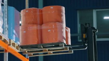 Forklift malları depodaki raflara koyuyor. Depo işi. Agrofiber ambarın rafına konmuş.