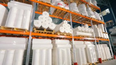 Dokumasız rulolarla dolu bir depo. Dokumasız bir kumaş fabrikasında büyük bir depo. Büyük bir tomar bono.