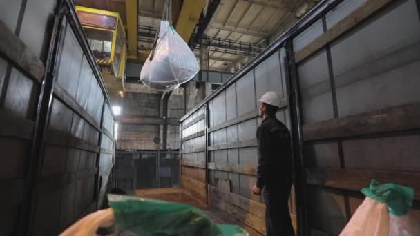 Les sacs à billes métalliques sont chargés dans un camion. Le processus de chargement de billes métalliques dans un camion. intérieur industriel — Video