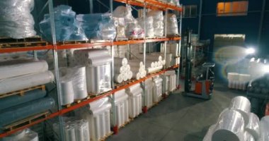 Forklift malları ambarın rafına koyuyor. Forklift, el değmemiş olanları fabrika deposunun rafına koyuyor. Dokumasız fabrikadaki depo..