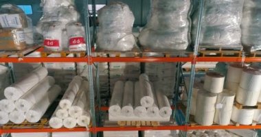 Dokumasız fabrikasındaki depo. Kumaşsız kumaş deposuna uçuş. Sentetik kış sarmalı büyük modern bir depo.