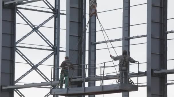 İşçiler metal yapılar boyuyor. İnşaat işi. Endüstriyel dış görünüş. İnşaatçılar binanın metal yapısını un ufak ediyorlar. — Stok video
