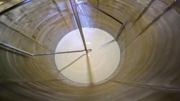 Ανακατεύοντας γάλα σ 'ένα εργοστάσιο. Το γάλα περιστρέφεται σε ένα μεγάλο βαρέλι. Προετοιμασία παγωτού. — Αρχείο Βίντεο