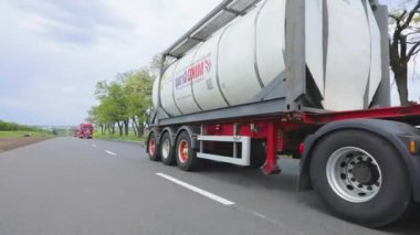 Kamyonlar yol boyunca gidiyor. Tank kamyonu olan bir kamyon otoyol boyunca yaklaşır. Tehlikeli malların nakliyesi