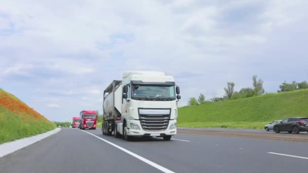 Bílý náklaďák jede po dálnici. Náklaďák s cisternou jede za slunečného počasí po dálnici. Po dálnici jezdí konvoj náklaďáků. — Stock video