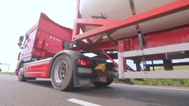 Trucks are driving along the road. A truck with a tank truck drives along the highway close-up. Transportation of dangerous goods — Stock Video