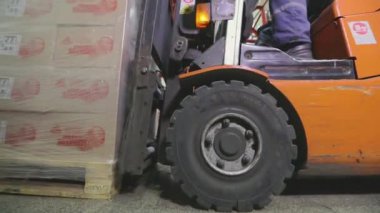 Depodan geçen bir forkliftin yakın çekimi. Forklift hareket halinde, yakın plan. Forklift tekerlekleri yakın çekim