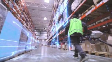 Bir işçi büyük bir depoda bir rokla taşıyor. İşçi depoya doğru yürür. Üretimin dijitalleştirilmesi. Gelecekçi üretim konsepti.