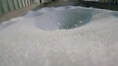 Polipropilen damlası. Plastik granüller yavaş çekimde düşer. Polipropilen granülleri yavaş çekimde yakınlaşır