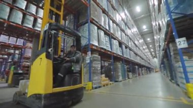 Modern forkliftte çalışan bir işçi. Büyük, modern bir depoda çalışıyorum. Modern bir depoda çalışma
