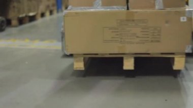 Büyük bir depoda bir adam hidrolik bir araba taşıyor. Depoda bir adam bir rokla taşıyor. Depo işçisi. Büyük modern depo